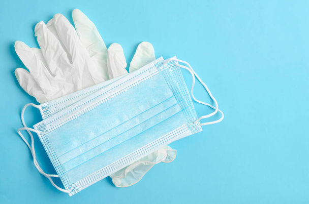 Disposable medical mask and gloves medical on a blue background. - Φωτογραφία, εικόνα