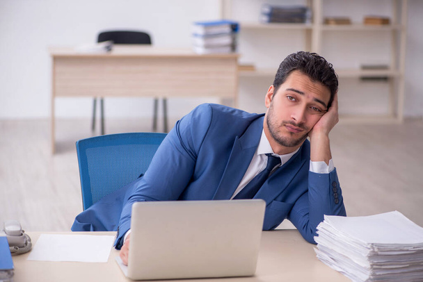 Young businessman employee and too much work at workplace - Photo, Image