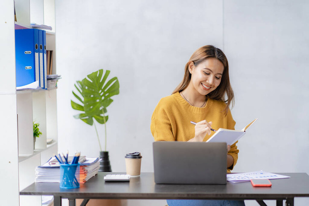Азиатская женщина, работающая онлайн с ноутбуком в домашнем офисе, красивая девушка, проводящая видеоконференцию в домашнем офисе, женщина, изучающая онлайн класс, изучающая концепцию деловых встреч - Фото, изображение