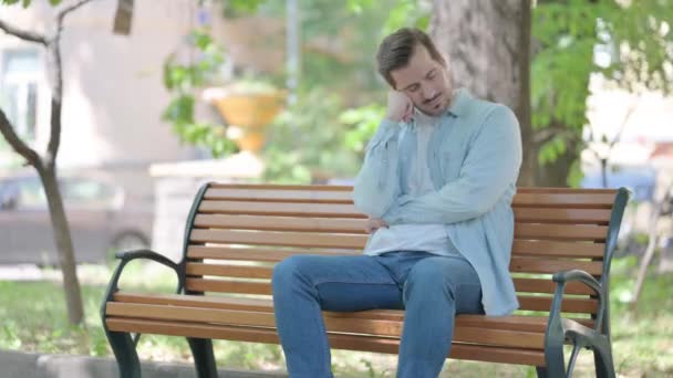 Sleeping Young Man Sitting Outdoor on Bench - Footage, Video