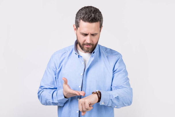 photo of punctual man check time on watch. punctual man with watch wearing casual shirt. punctual man with watch isolated on grey background. punctual man with watch in studio. - Photo, Image