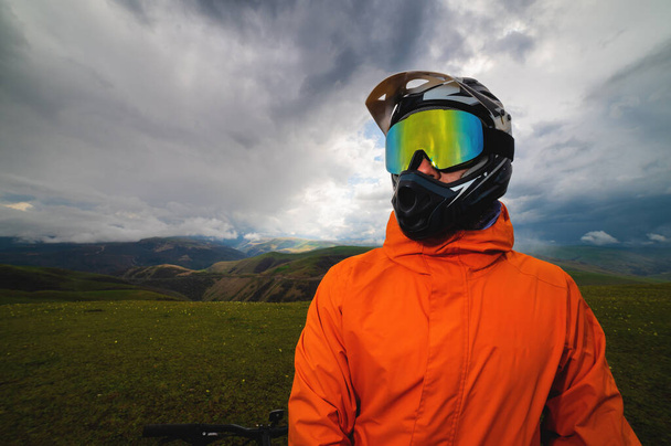 close-up, portrait of a biker in a sports helmet covering the entire face and glasses, the concept of off-road travel by bike, extreme lifestyle. - Фото, изображение