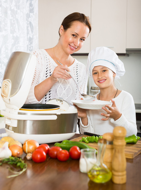 Girl and mom with rice cooker - Фото, изображение
