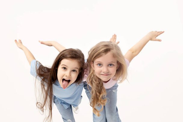 Group portrait of kids girls friends on white studio background. Happy children, cute girls hugging and having fun in carnival glasses. funny faces - Foto, Imagem