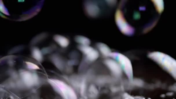 Close up, Lots of Colorful Stuck Together Soap Bubbles on a Brown Wooden Surface. Transparent rainbow bubbles with foam fly, connect, burst. Bubble bunch. Splash. Structure. Blurred motion. Abstract. - Footage, Video
