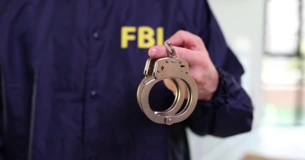 FBI police agent holding handcuffs closeup. Federal Bureau of Investigation delay arrest perpetrator - Footage, Video