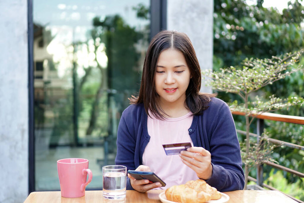 Ázsiai nők használnak hitelkártyák és okostelefonok egy kávézóban. - Fotó, kép