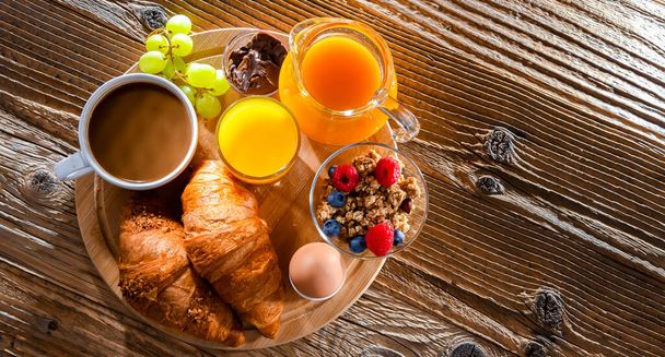 Breakfast served with coffee, orange juice, croissants and egg. - Photo, Image