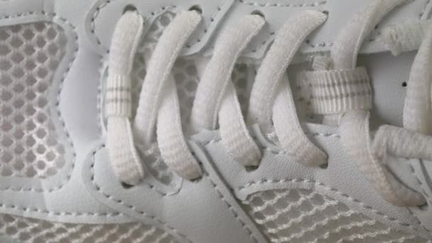 Close-up, Perforated White Leather Sneaker Surface Texture. Laces, mesh, holes, fabric structure. Side view. Slow camera movement from toe to heel. Inside. Female shoe for fitness. Sports concept. - Footage, Video