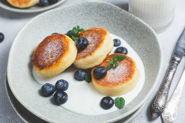 Cottage cheese pancakes with cream sauce and blueberries - Foto, Imagen