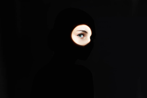 暗闇の中の美しい少女のシルエット。顔に影のある若い女性。女性の目 - 写真・画像