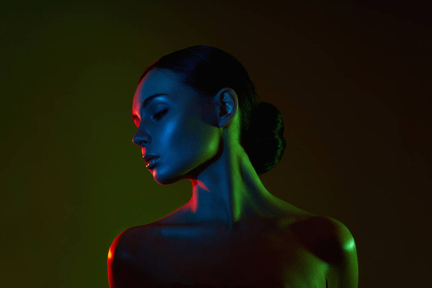 beautiful woman in color lights. Sensual girl with radiance body - 写真・画像