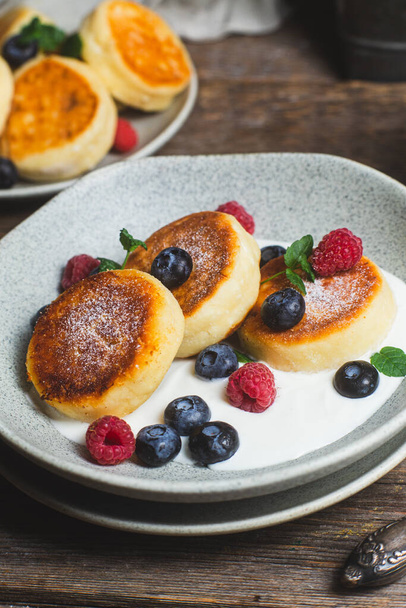 Cottage cheese pancakes with creamy sauce, raspberries and blueberries - Fotografie, Obrázek