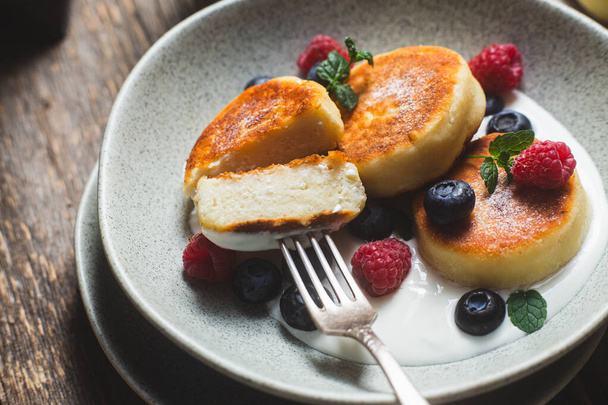 Cottage cheese pancakes with creamy sauce, raspberries and blueberries - Photo, Image