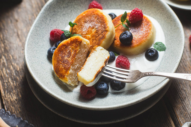 Cottage cheese pancakes with creamy sauce, raspberries and blueberries - Zdjęcie, obraz
