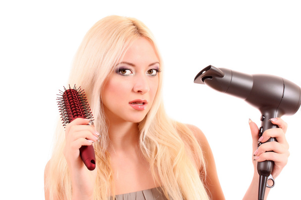 Beautiful young blonde woman brushing her long hair - Foto, Imagen