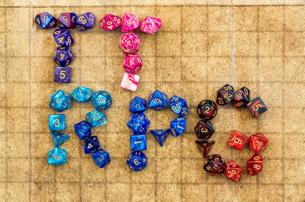 Immagine aerea di vibrante RPG dadi ortografia 'ttrpg' su una griglia di battaglia per giochi da tavolo RPG - Foto, immagini