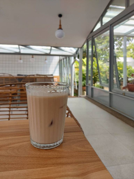 szklankę zimnej herbaty mlecznej na drewnianym stole  - Zdjęcie, obraz