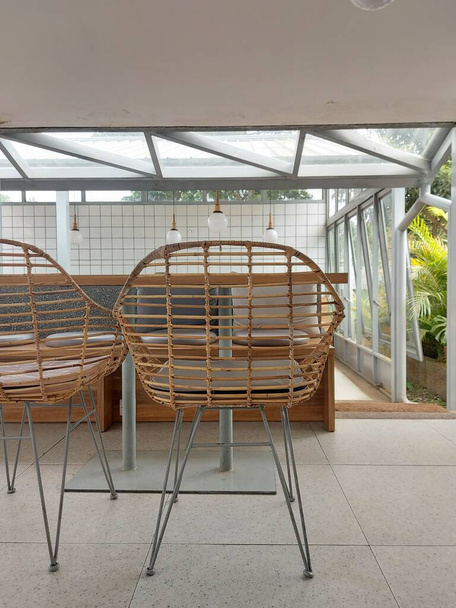 美しい籐製の椅子と木製のテーブルがある空のカフェの雰囲気 - 写真・画像