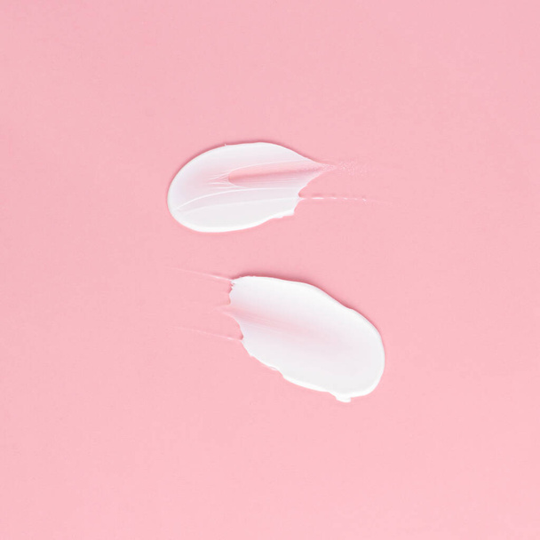 Smear of white cream for face and body on a pink background - Photo, Image