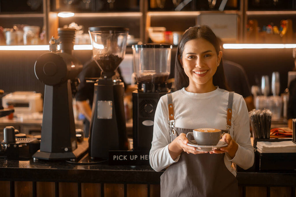 Latte art in barista hand ready to drink in modern coffee shop - Foto, Imagen