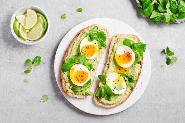アボカドの卵のトースト、アボカドとトーストパンの卵、明るい背景に健康的なスナックや朝食。 - 写真・画像