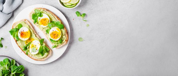 Τοστ αυγού αβοκάντο, αυγά σε φρυγανισμένο ψωμί με αβοκάντο, υγιεινό σνακ ή πρωινό σε φωτεινό φόντο - Φωτογραφία, εικόνα