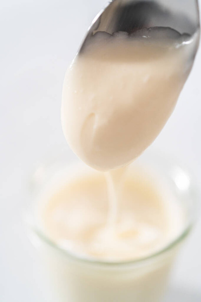 Cream cheese glaze in small glass jat. - Foto, Imagem