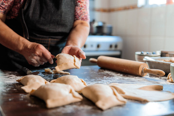 Aromit Heritage: Latina Vanhukset nainen valmistelee Chilen paistettua naudanlihaa Empanadas lämmössä kotiinsa keittiö. Laadukas kuva - Valokuva, kuva