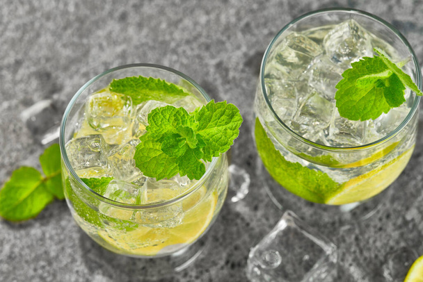 Two glasses of mojito cocktail on a grey background.Top view. Studio shot. - Foto, afbeelding