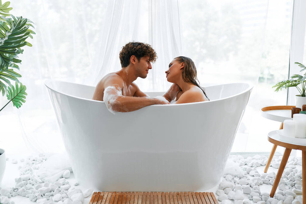 Сексуальная романтическая чувственная молодая пара обнимается и принимает ванну с пеной. Страстная леди отдыхает в ванной со своим говядиной бойфрендом. - Фото, изображение