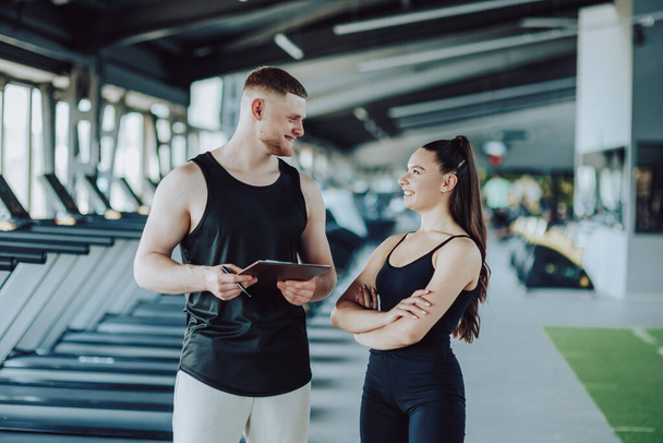 Confident gym-goers Portrait of a young man and woman in sportswear, camera-ready. Powerful Presence Gym Portrait of a Young Man and Woman - Photo, Image