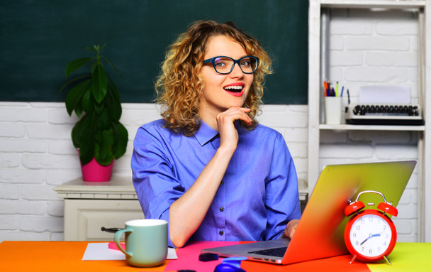 Молодая счастливая деловая женщина сидит за рабочим столом с ноутбуком. Профессиональный онлайн-учитель кузнечной школы рекламирует виртуальные заочные занятия студентов, обучающих веб-бинарам дистанционного обучения. Портрет - Фото, изображение