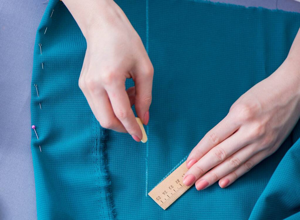 Γυναίκα ράφτης που εργάζεται σε ένα ράψιμο ενδυμάτων μετρώντας ύφασμα - Φωτογραφία, εικόνα