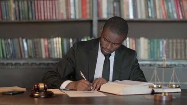 Pensive Африканський юрист написання юридичних документів в офісі - Кадри, відео