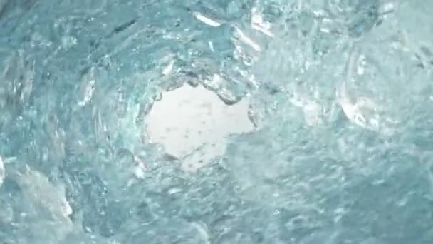 Супер повільний постріл чистої води і кубиків льоду, що обертаються хвилею на швидкості 1000 кадрів/с. Знято з високошвидкісною кінокамерою, 4K. - Кадри, відео
