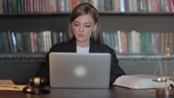 Молодая женщина-юрист работает над ноутбуком - Кадры, видео
