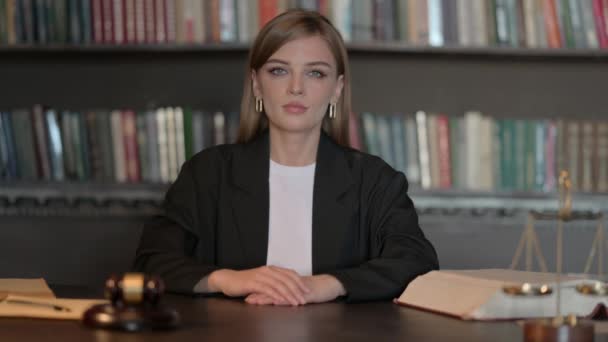 Σοβαρή νεαρή γυναίκα δικηγόρος κάθεται στο γραφείο - Πλάνα, βίντεο