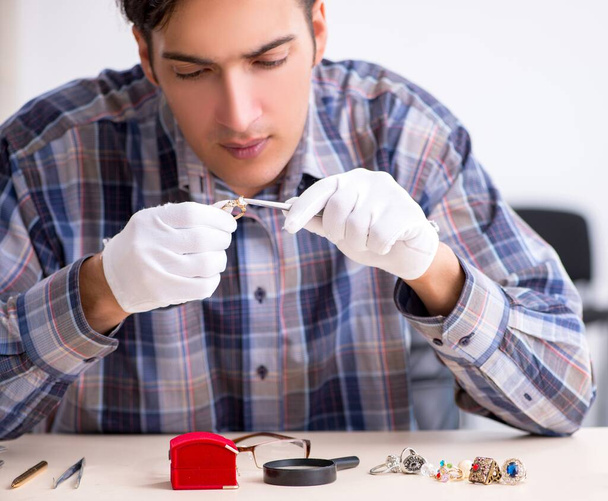 The young male jeweler at workshop - 写真・画像