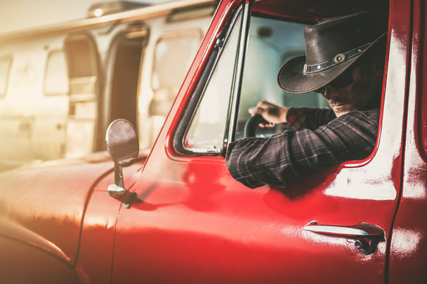 Vaquero caucásico de mediana edad en una camioneta clásica junto a su remolque de viaje - Foto, imagen
