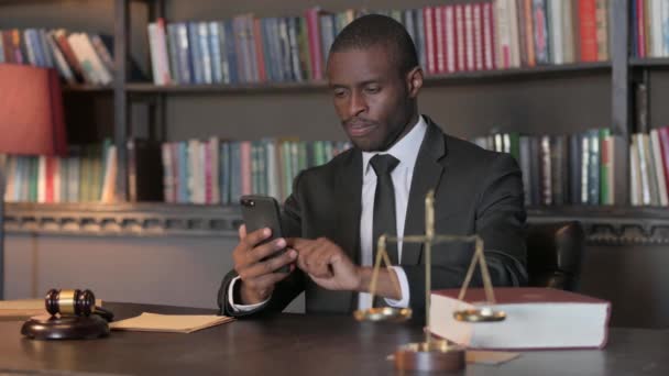 Афроамериканский юрист празднует победу на смартфоне в офисе - Кадры, видео