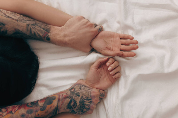 Passionate couple having sex on bed, closeup of hands - Fotografie, Obrázek