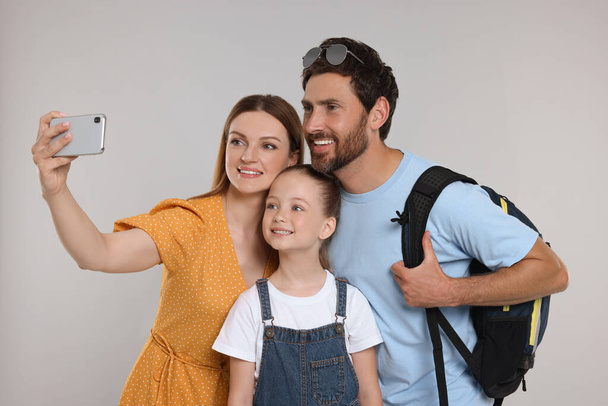 Happy family taking selfie on light grey background - Photo, Image