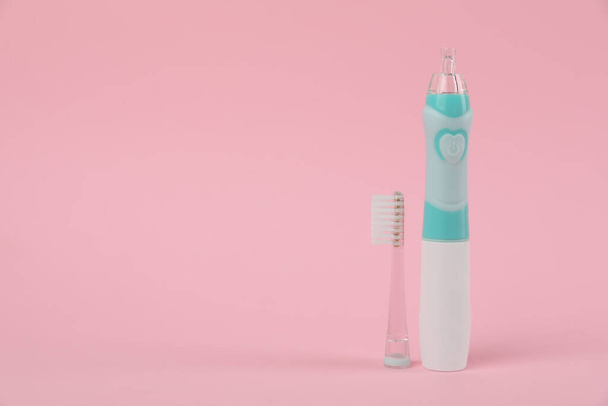 Electric toothbrush on pink background, space for text - Foto, imagen