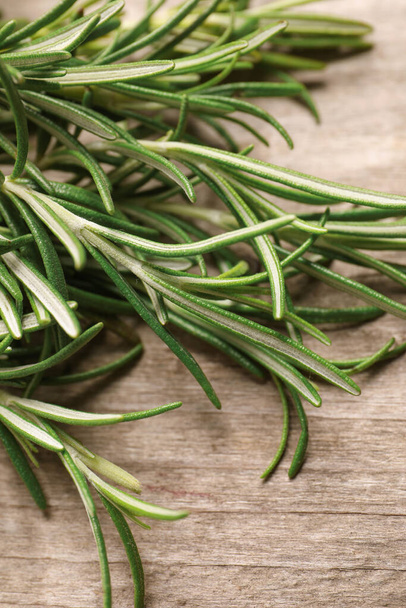 Sprigs of fresh rosemary on wooden table, closeup - Photo, image
