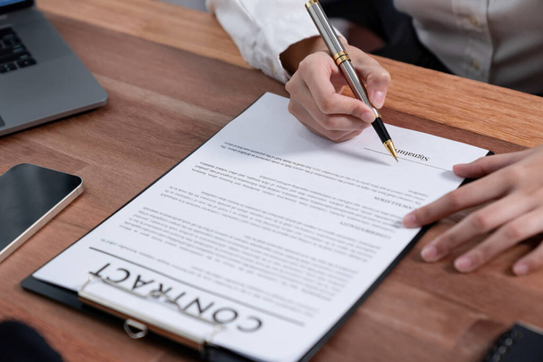 Closeup hand signing contract document with pen, sealing business deal with signature. Businesspeople finalizing business agreement by writing down signature on contract paper. Enthusiastic - Photo, Image