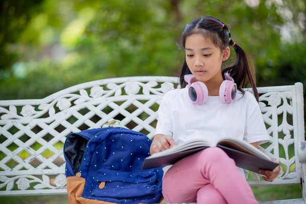 De volta à escola. Menina asiática lendo um livro. Estudantes do ensino primário após as aulas aprendendo lição de casa. - Foto, Imagem