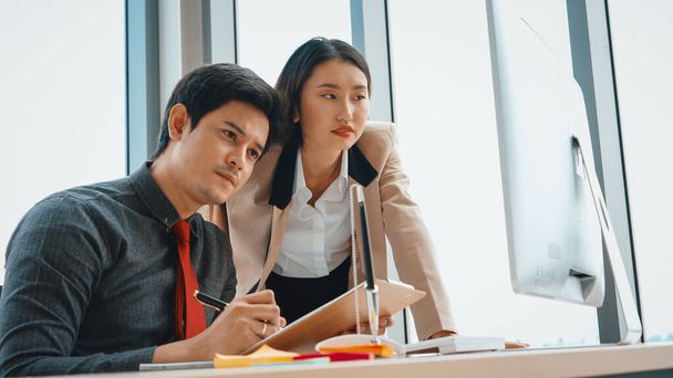 Two business people talk project strategy at office meeting room. Businessman discuss project planning with colleague at modern workplace while having conversation and advice on financial report. Jivy - Foto, imagen