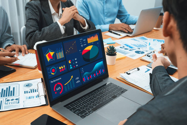 Multiracial analyst team use BI Fintech software to analyze financial data on meeting table. Financial dashboard data display on laptop screen with analyzed chart for marketing indication. Concord - 写真・画像