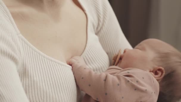 Medium closeup with slowmo of beautiful infant baby sleeping in loving mother arms at home - Imágenes, Vídeo